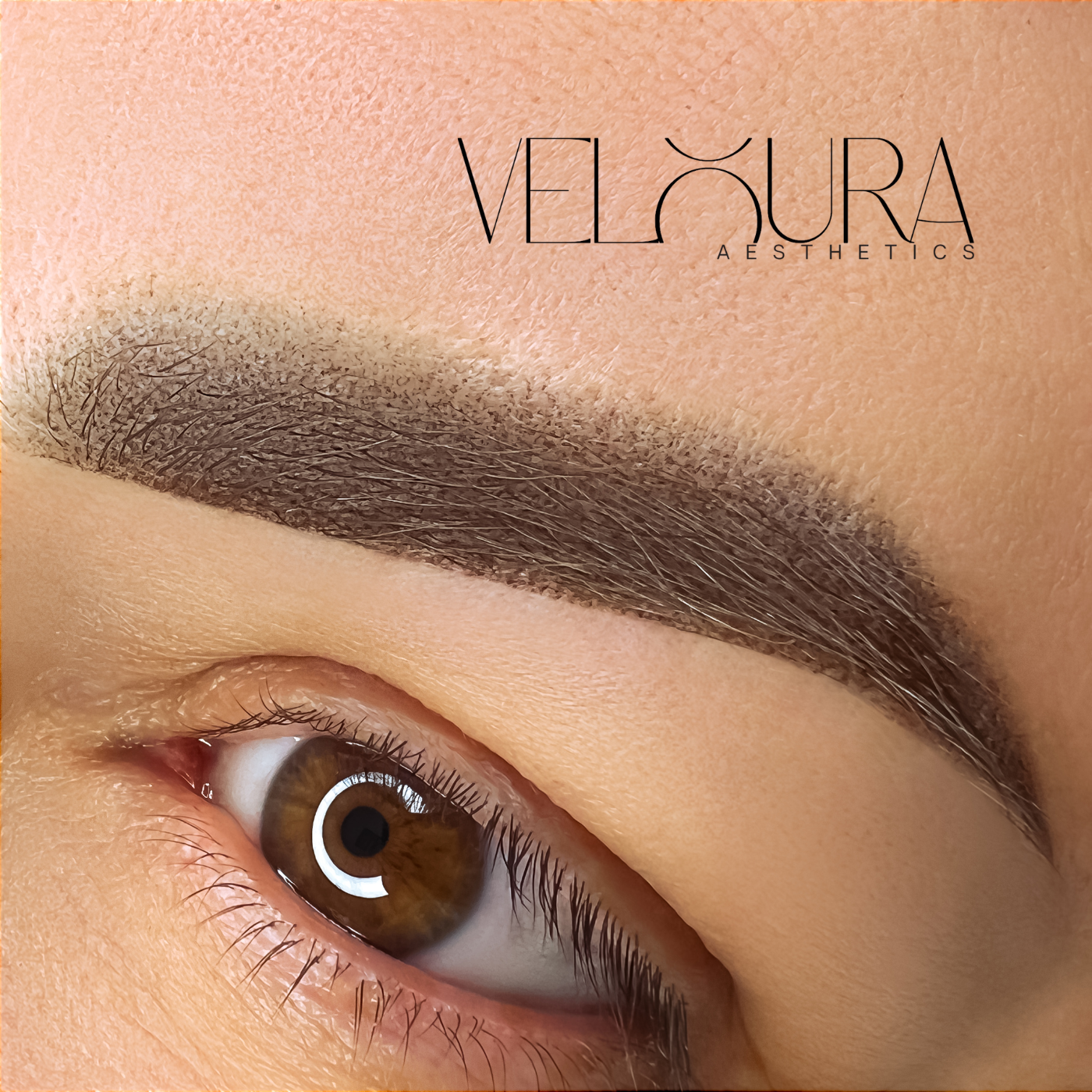 Close-up of an eye with a well-groomed eyebrow, featuring the Veloura Aesthetics logo.